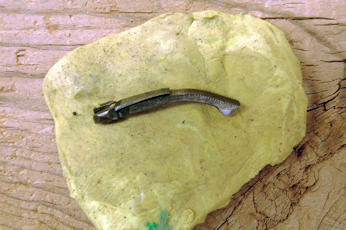 The ejector has a tiny flat spring crimped to its back. Whether it is nonfunctional or broken off seems to make no difference to ejection. Cases still eject flawlessly.